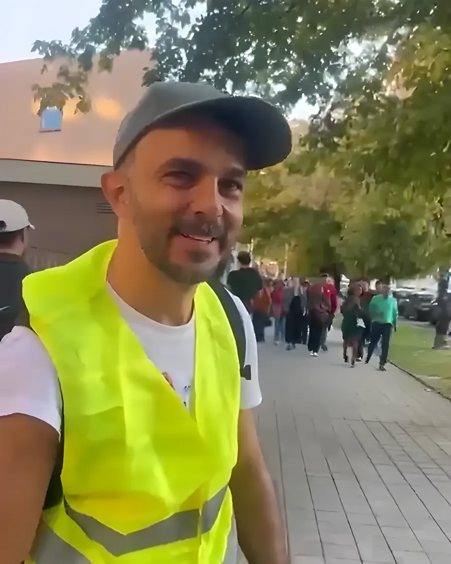 O Andrey no Porto, de colete e mochila, perto da fila de votação
