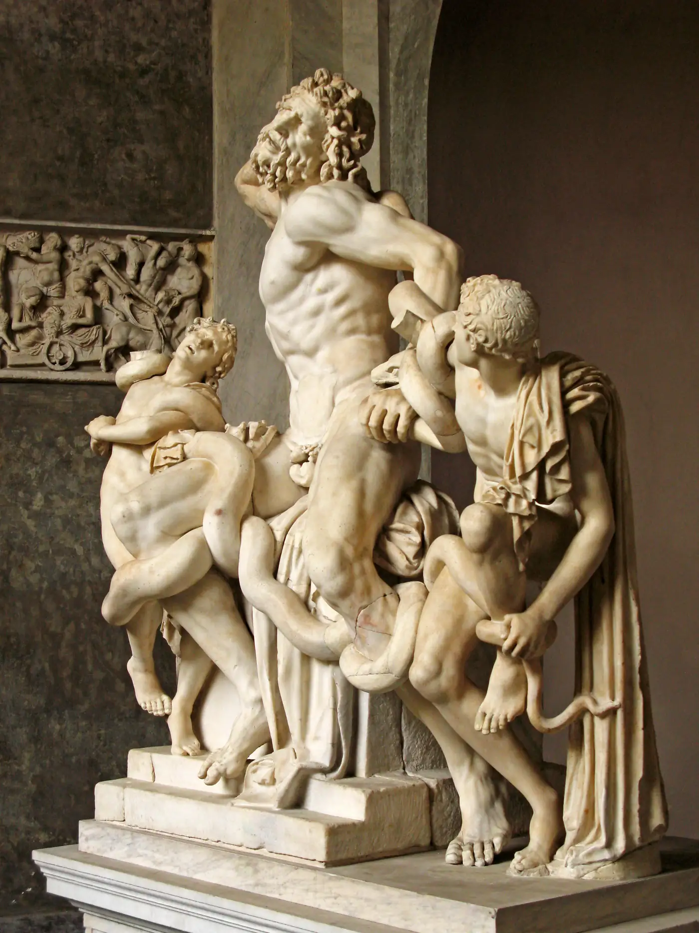 Estátua de mármore de um homem e dois jovens sendo atacados por serpentes, o grupo escultórico de Laocoonte, nos Museus do Vaticano
