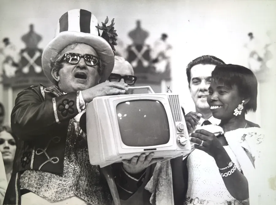 Chacrinha entrega um televisor à vencedora da disputa de melhor calouro da noite. Arquivo Nacional, domínio público