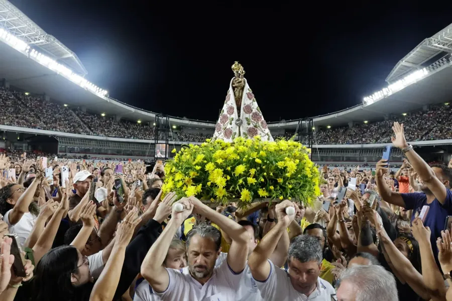 A Imagem Peregrina de Nossa Senhora de Nazaré no meio da multidão, com o estádio aceso