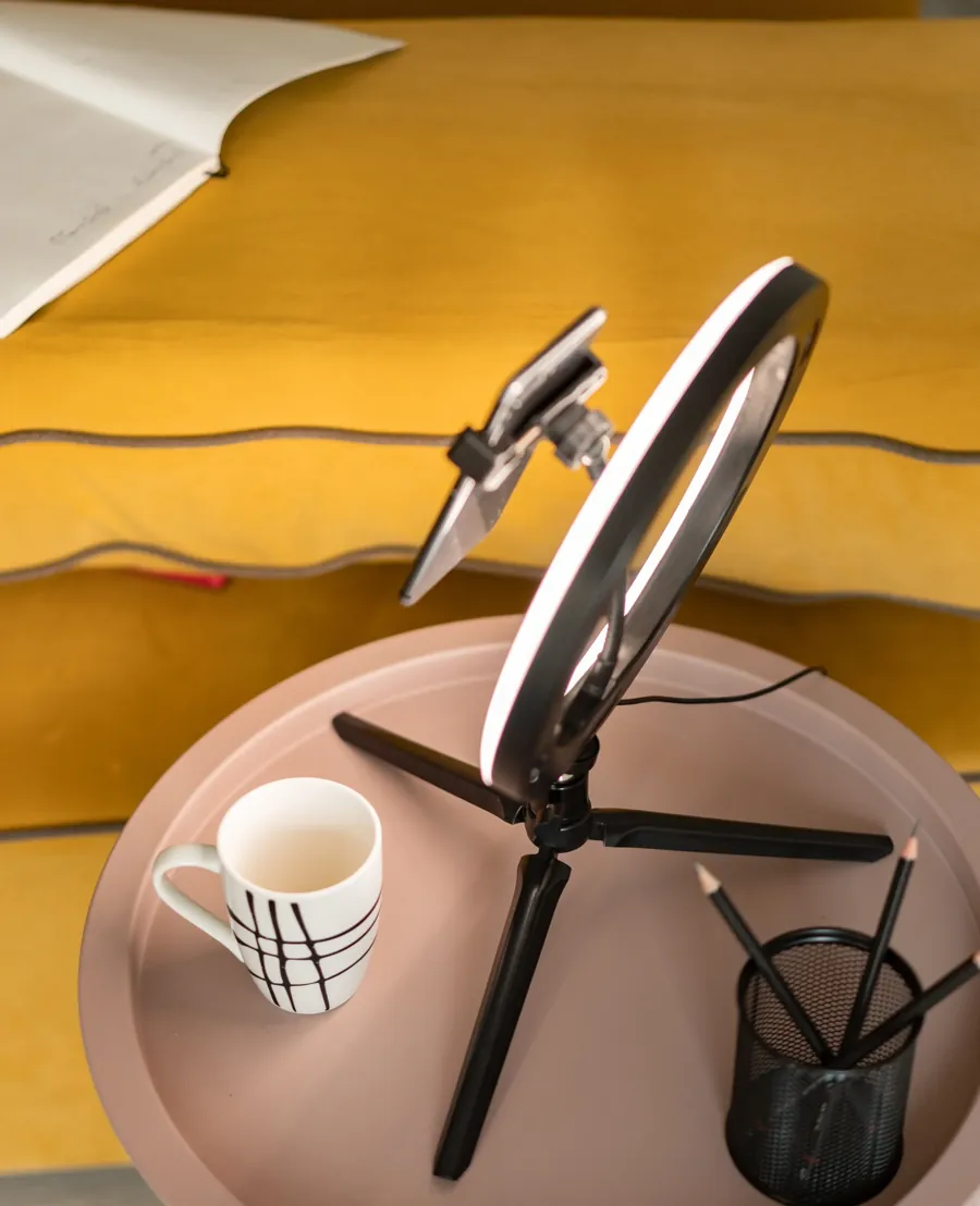 Celular preso no ring light, num tripé de mesa (foto ilustrativa). Mikhail Nilov/Pexels, licença Pexels
