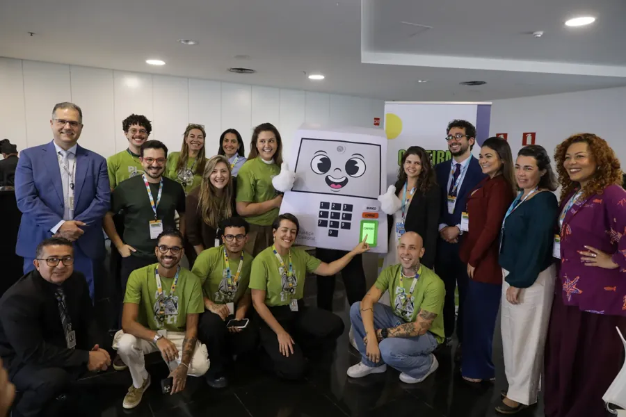 Equipe do TSE com o mascote da urna em evento de agosto de 2026. Foto: O Tribunal da Democracia / Wikimedia Commons, domínio público