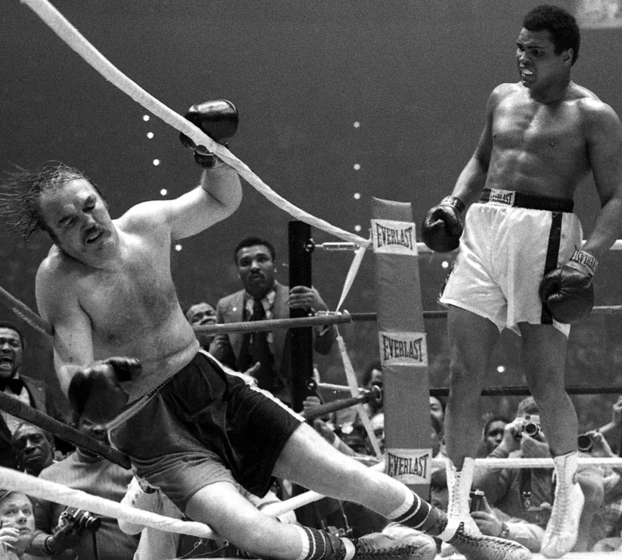 Chuck Wepner cai nas cordas diante de Muhammad Ali, na luta de 24 de março de 1975, em Ohio. Foto: Paul Tepley, Cleveland Press, domínio público